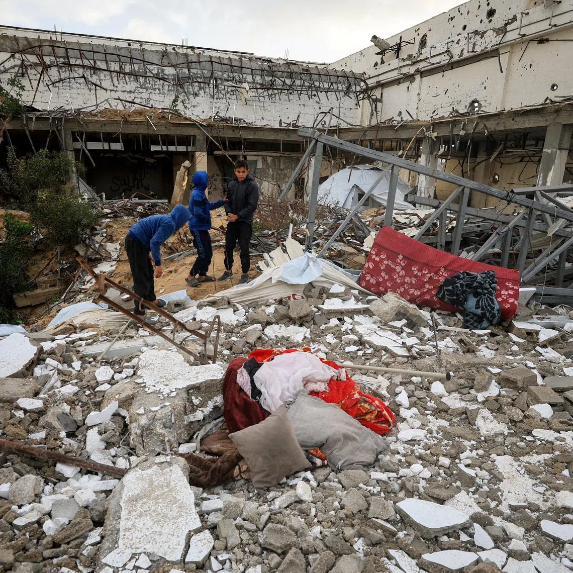 Palestinians inspect the damage at the site of a war-damaged building after parts of it collapsed, on a windy winter day, in Gaza City, January 13, 2026. REUTERS/Dawoud Abu Alkas