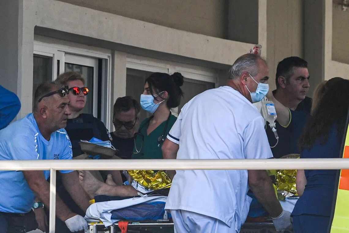 An injured man arriving for hospital treatment on Oct 9, following an oil refinery accident in Greece.