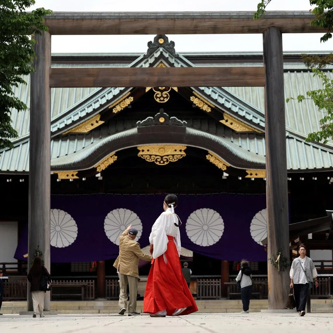 A shrine maiden walks at Yasukuni Shrine during the shrine's spring festival in Tokyo on April 21.