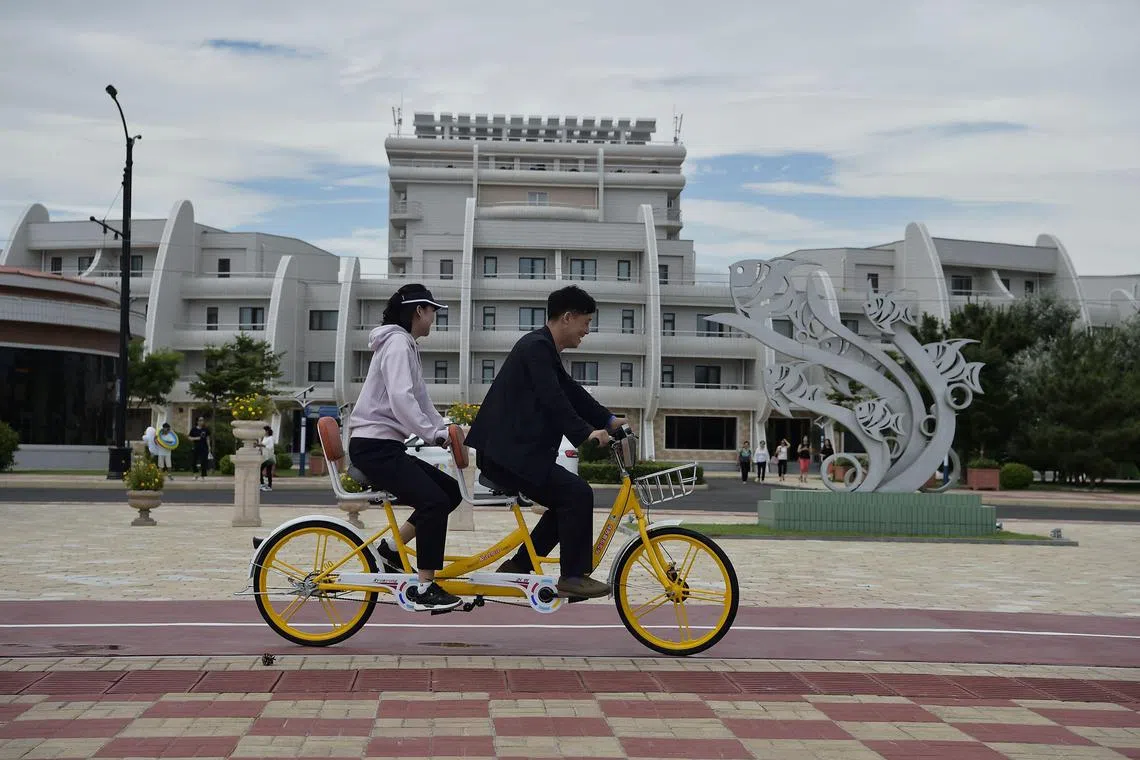 Domestic tourists ride a bicycle at Wonsan Kalma Coastal Tourist Area in Wonsan, North Korea's Kangwon Province on July 2, 2025. 
