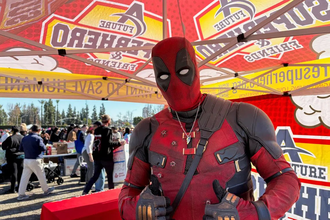 Yuri Williams, dressed as the superhero Deadpool, poses for a photo at a donation site for families displaced by the Los Angeles wildfires, in Arcadia, California, U.S., January 12, 2025. REUTERS/Lisa Richwine