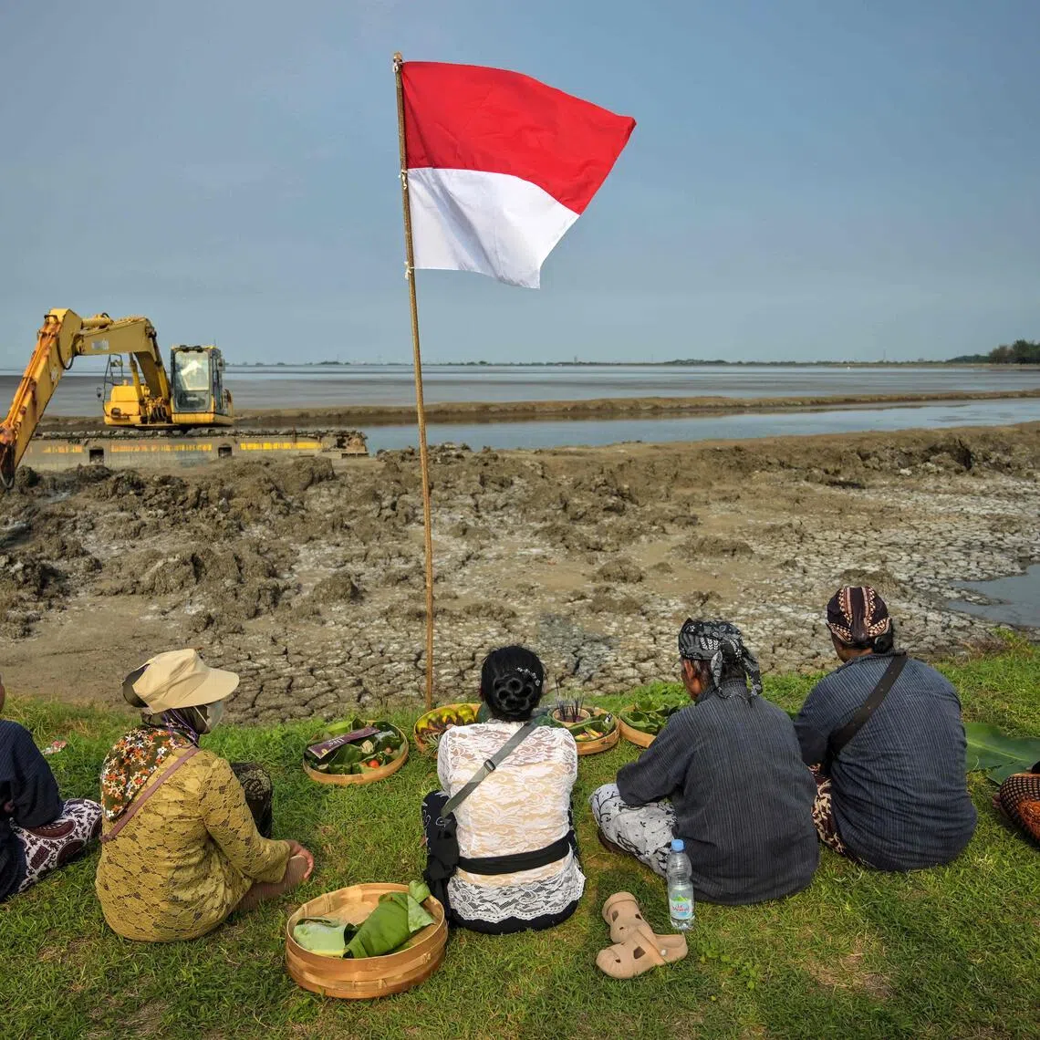Residents affected by the Lapindo mudflow gather with environmental activists to offers prayers at the embankment of the mud volcano area.