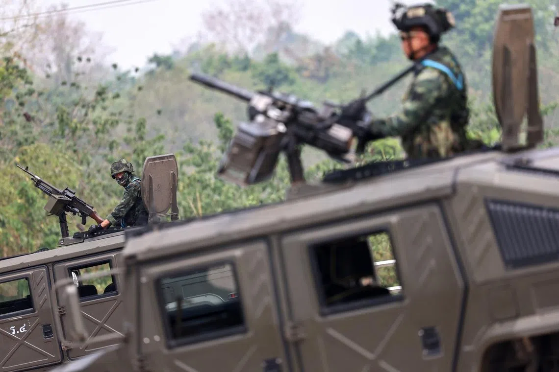 Military personnel stand guard, as a stream of people, some of them fearing air strikes, queued at a border crossing to flee Myanmar early on Friday, a day after the strategically-vital town of Myawaddy adjoining Thailand fell to anti-junta resistance that has been growing in strength, in Mae Sot, Tak province, Thailand, April 12, 2024. REUTERS/Athit Perawongmetha