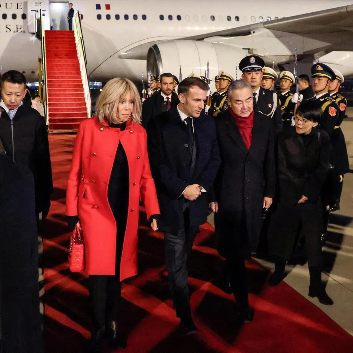Chinese Foreign Minister Wang Yi receiving French President Emmanuel Macron and his wife Brigitte at Beijing’s airport on Dec 3. 