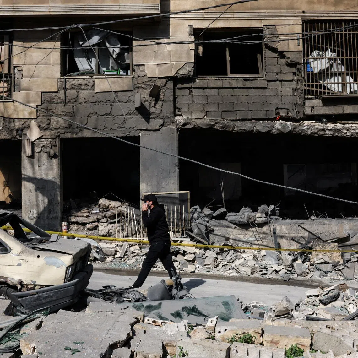 A man walks past a damaged building in the aftermath of Israeli strikes on the Bachoura neighbourhood, following an escalation between Hezbollah and Israel amid the US-Israeli conflict with Iran, Lebanon, on March 13, 2026.