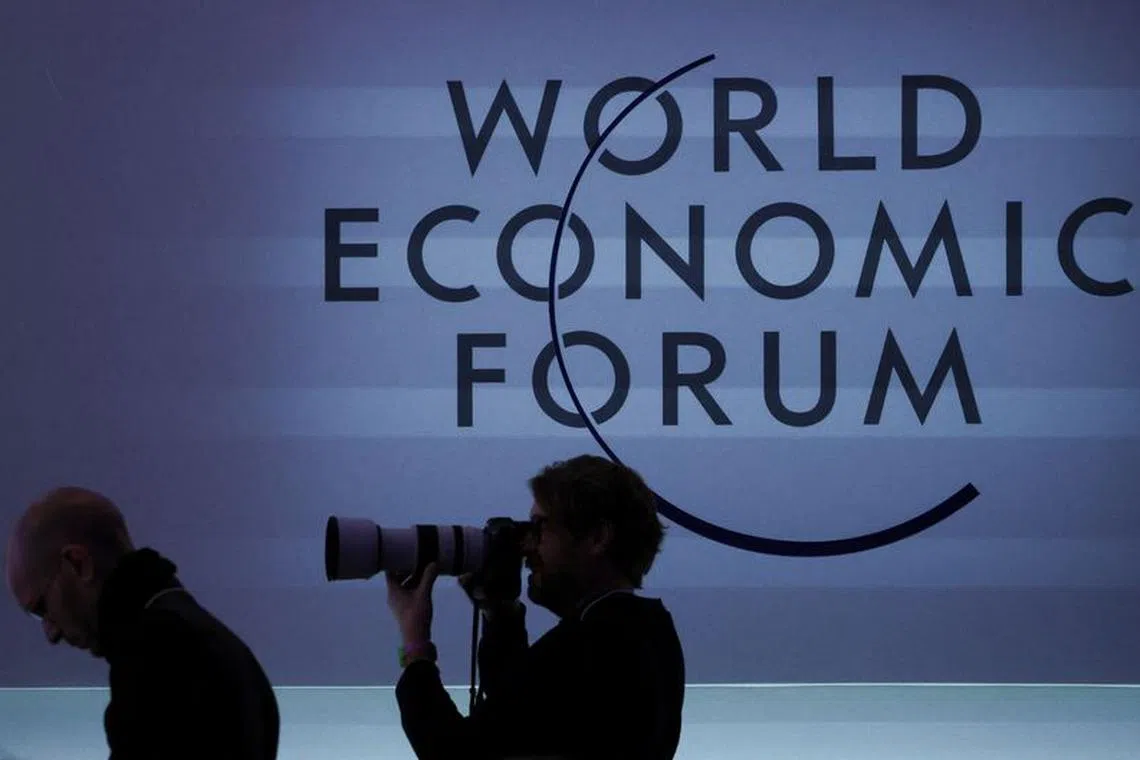 A person takes a photo next to a logo during the 54th annual meeting of the World Economic Forum, in Davos, Switzerland, January 19, 2024. REUTERS/Denis Balibouse/ File Photo