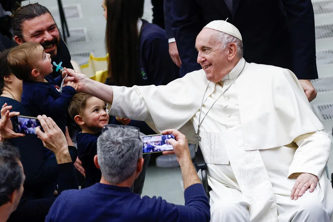 Pope Francis greets people as he attends the weekly general audience at the Paul VI Hall at the Vatican on Dec 14, 2022. 