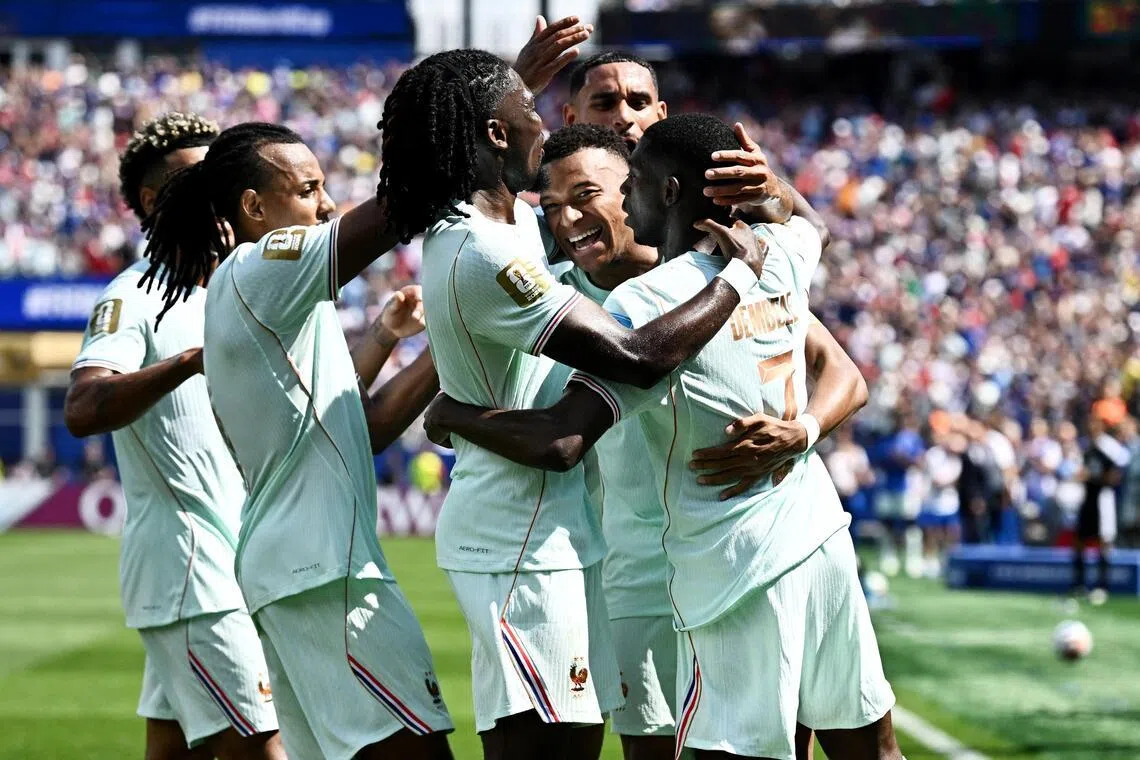 France’s Ousmane Dembele celebrates scoring their third goal with teammates, completing his hat-trick.