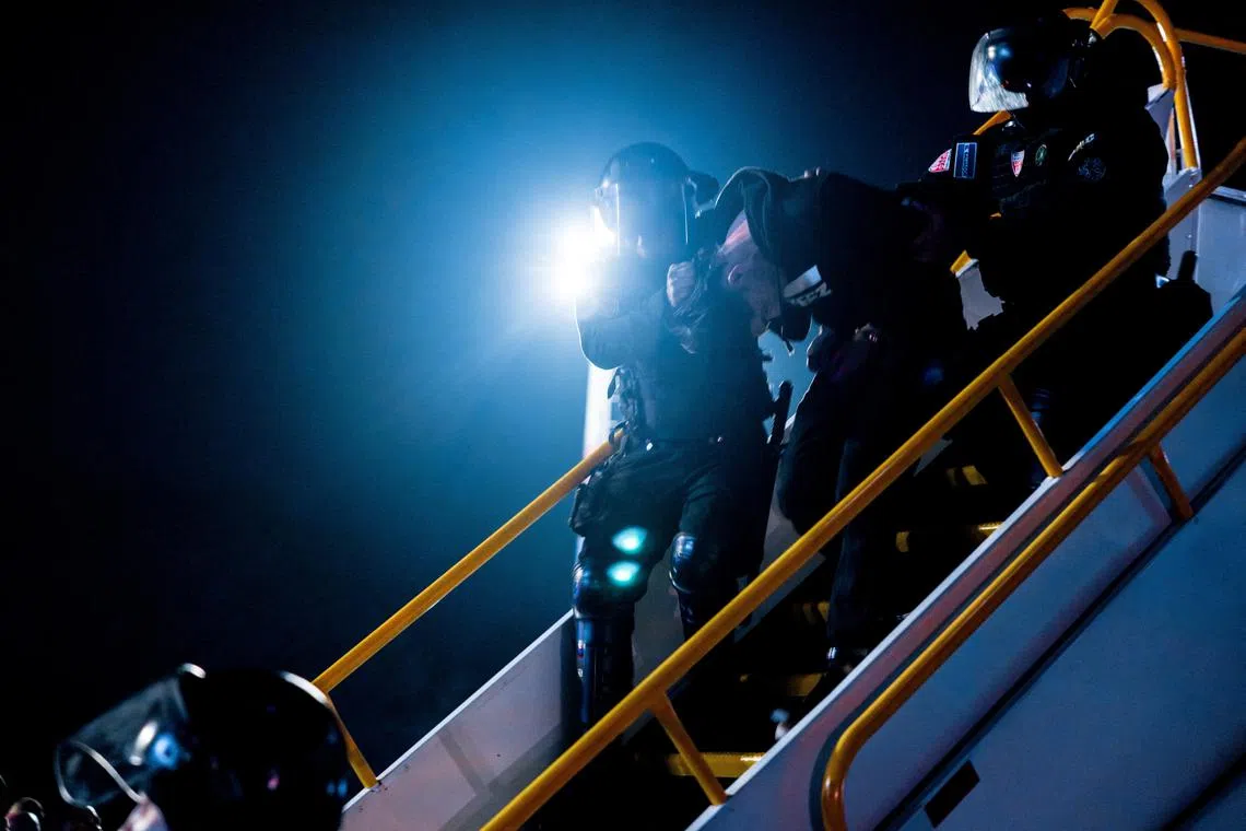 Salvadoran police officers escort alleged members of the Venezuelan gang Tren de Aragua recently deported by the U.S. government to be imprisoned in the Terrorism Confinement Center (CECOT) prison, as part of an agreement with the Salvadoran government, at the San Oscar Arnulfo Romero international airport in San Luis Talpa, El Salvador, in this handout image obtained March 16, 2025. Secretaria de Prensa de la Presidencia/Handout via REUTERS/File Photo