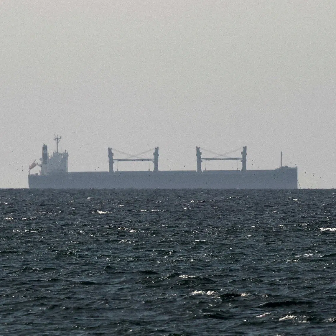 FILE PHOTO: A cargo ship in the Gulf, near the Strait of Hormuz, as seen from northern Ras al-Khaimah, near the border with Oman’s Musandam governance, amid the U.S.-Israeli conflict with Iran, in United Arab Emirates, March 11, 2026. REUTERS/Stringer/File Photo