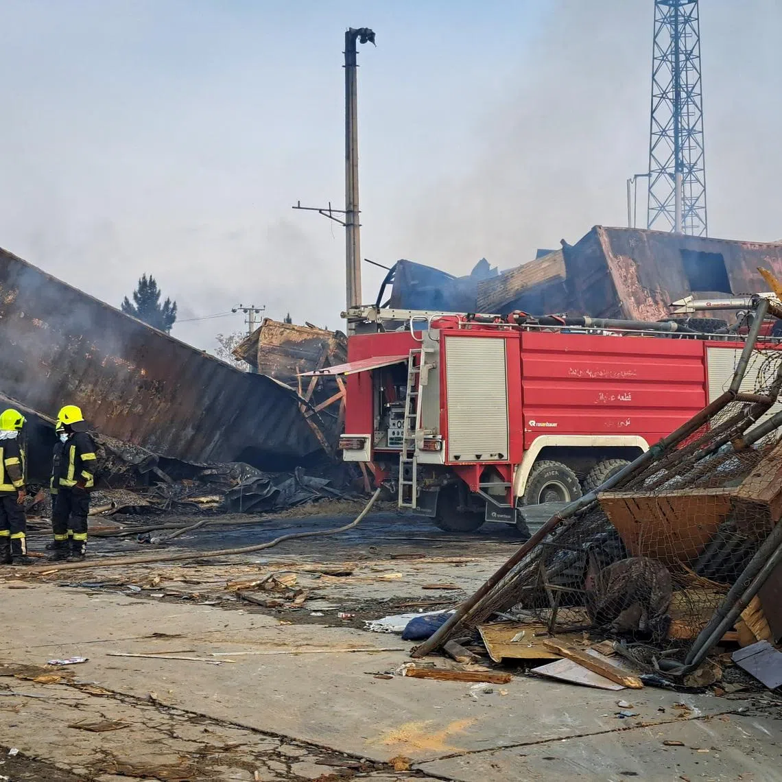 Firefighters stand next to a fire truck at the site of a drug users rehabilitation hospital destroyed in what the Taliban said was a Pakistani air strike in Kabul, Afghanistan, March 17, 2026. REUTERS/Yunus Yawar
