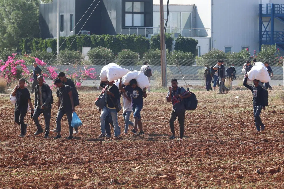 FILE PHOTO: Migrants leave Pournara refugee camp during clashes in Kokkinotrimithia on the outskirts of Nicosia, Cyprus October 28, 2022. REUTERS/Yiannis Kourtoglou/File Photo