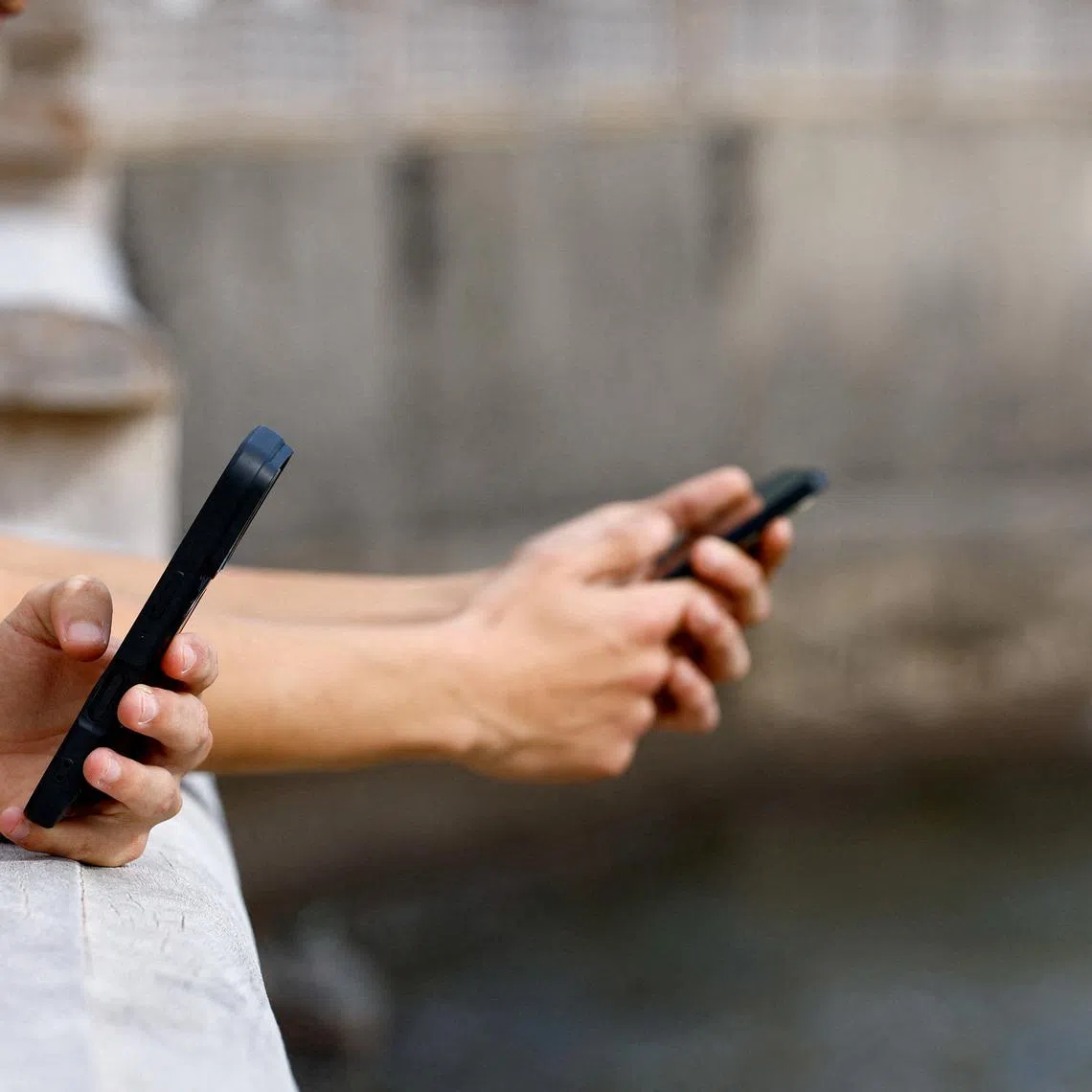 FILE PHOTO: Two 15-year-olds use social media on their mobile phones in Arinaga, on the island of Gran Canaria, Spain, February 3, 2026. REUTERS/Borja Suarez/File Photo