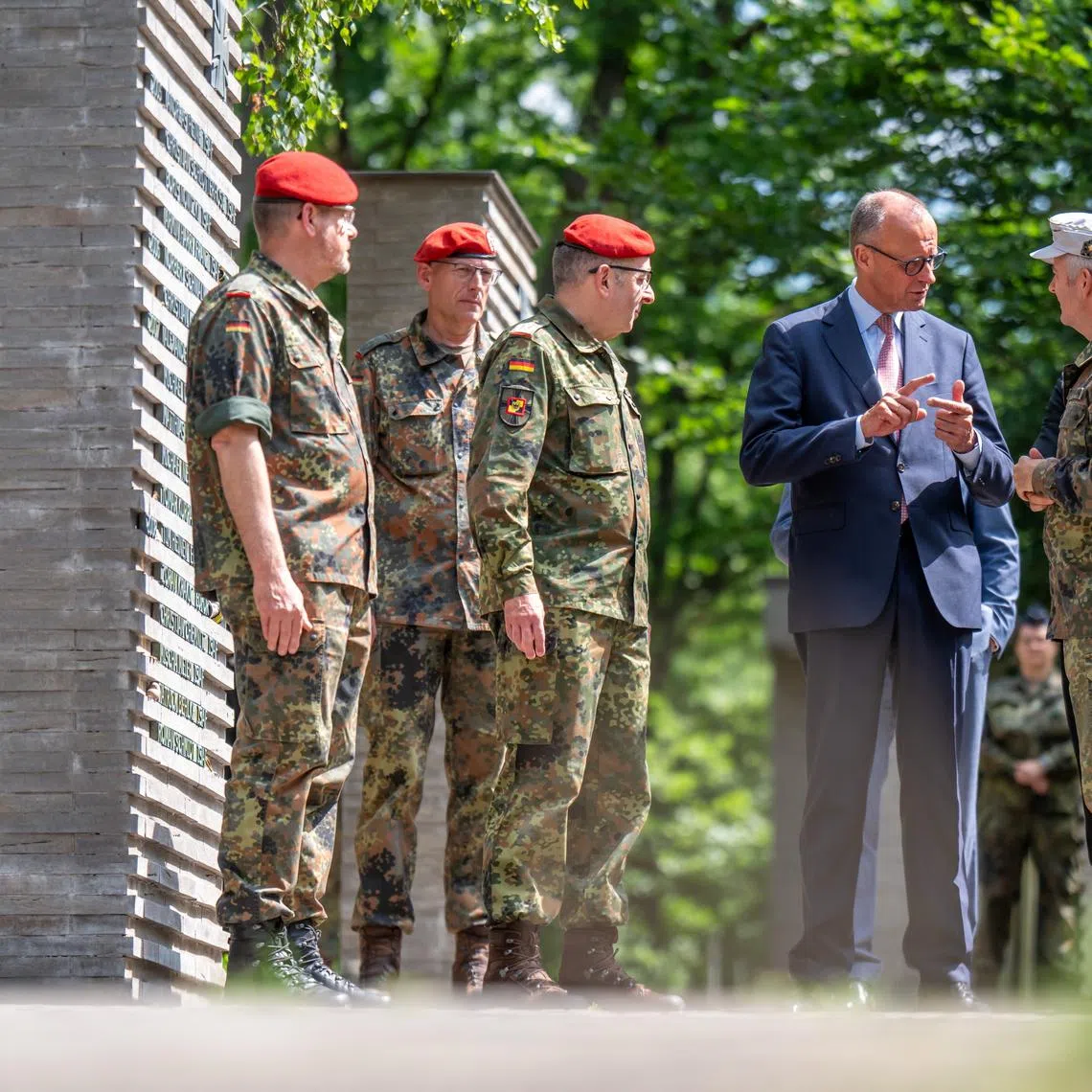FILE PHOTO: German Chancellor Friedrich Merz talks to soldiers in the so-called \"Forest of Remembrance\" following his visit to the Operational Command of the German armed forces Bundeswehr in Schwielowsee near Berlin, Germany, June 28, 2025.     Michael Kappeler/Pool via REUTERS/File Photo