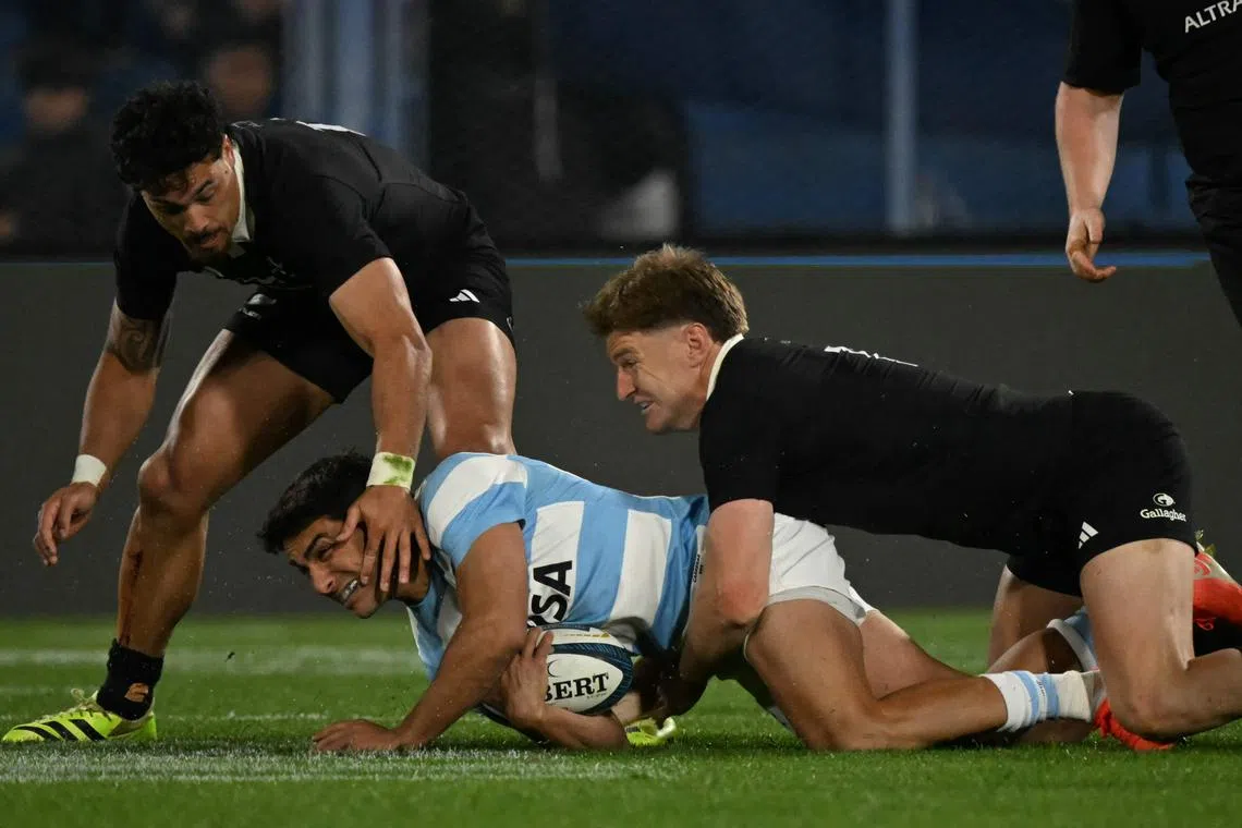 Argentina fly-half Santiago Carreras is tackled by New Zealand hooker Codie Taylor in the Rugby Championship at the Jose Amalfitani Stadium in Buenos Aires on Aug 23, 2025.