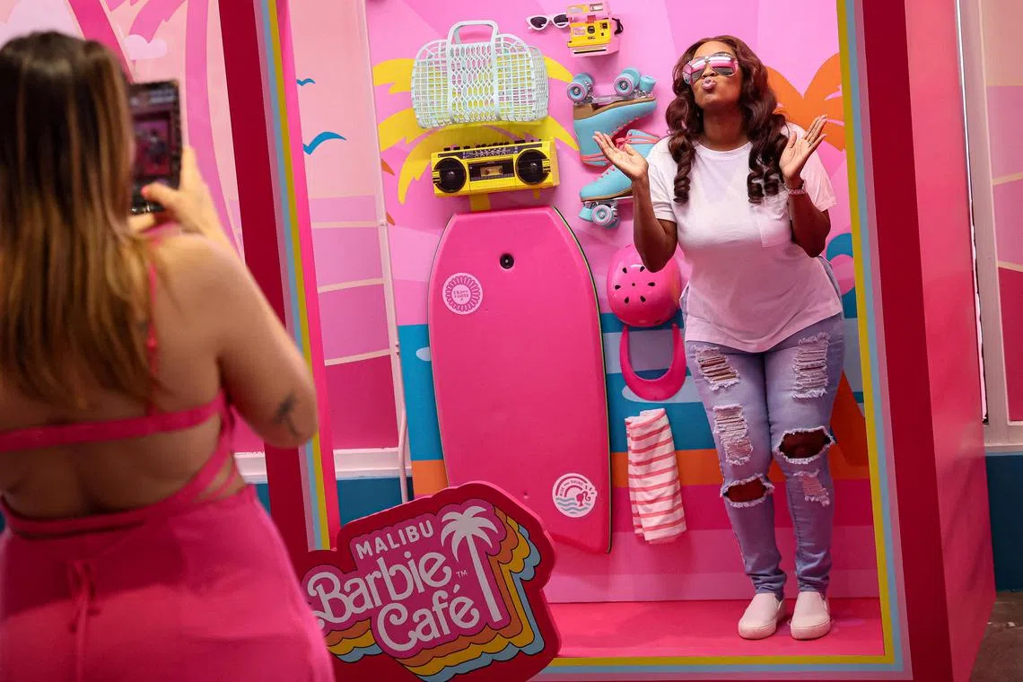 A guest poses for photos at the new Malibu Barbie Cafe pop-up in New York City, U.S., May 17, 2023.  REUTERS/Brendan McDermid    