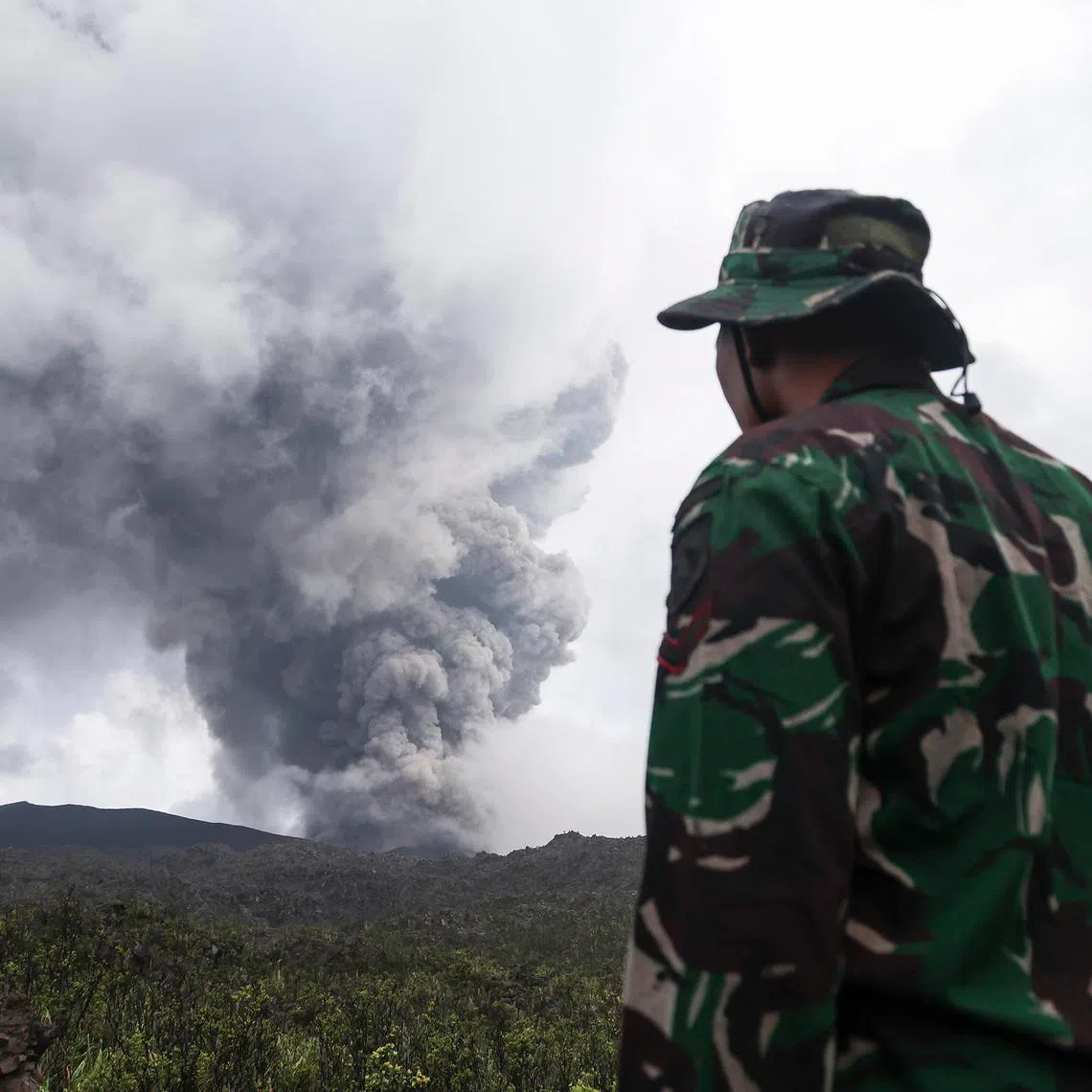 A rescuer looks on Mount Dukono Volcano during its eruption in North Halmahera, Indonesia, on May 9.