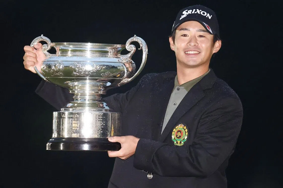 Naoyuki Kataoka smiling with the trophy after winning the Japan Open golf tournament.