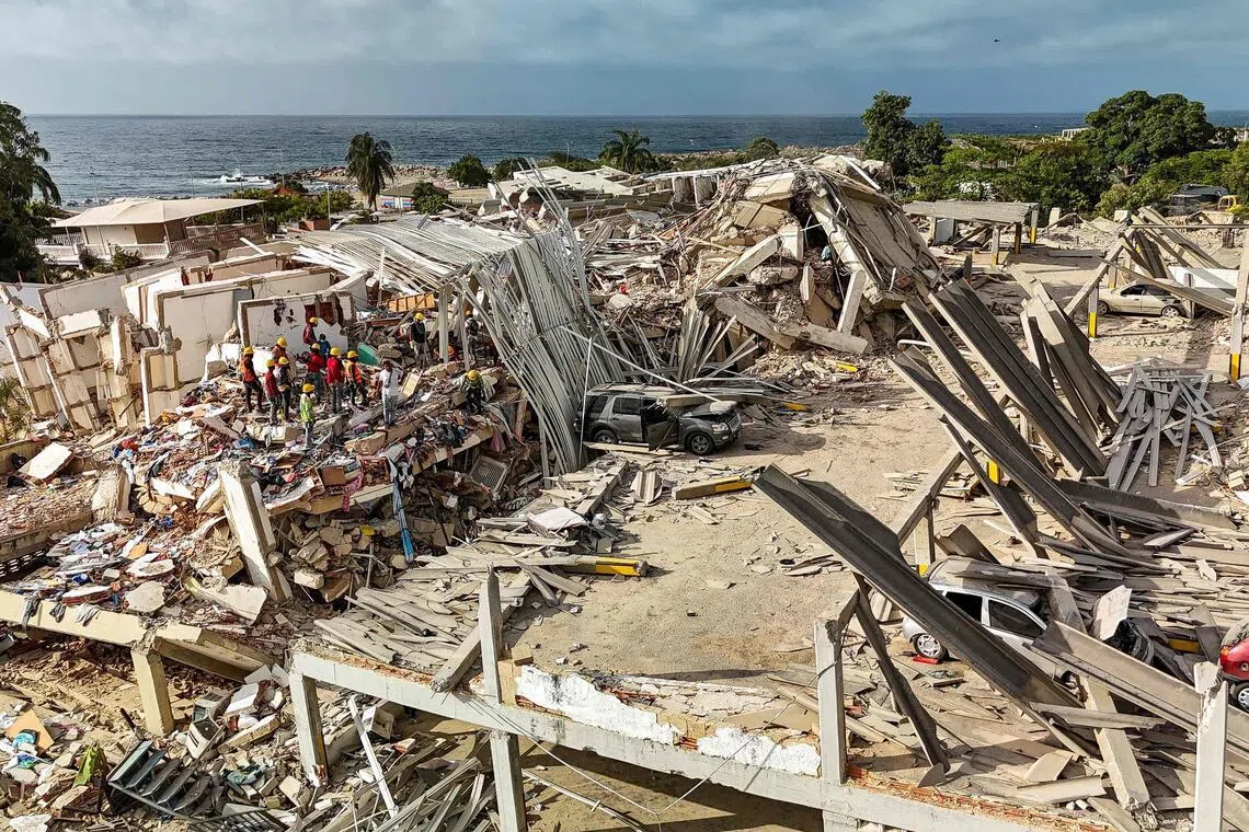 A painful wait by a pile of rubble in quake-hit Venezuela