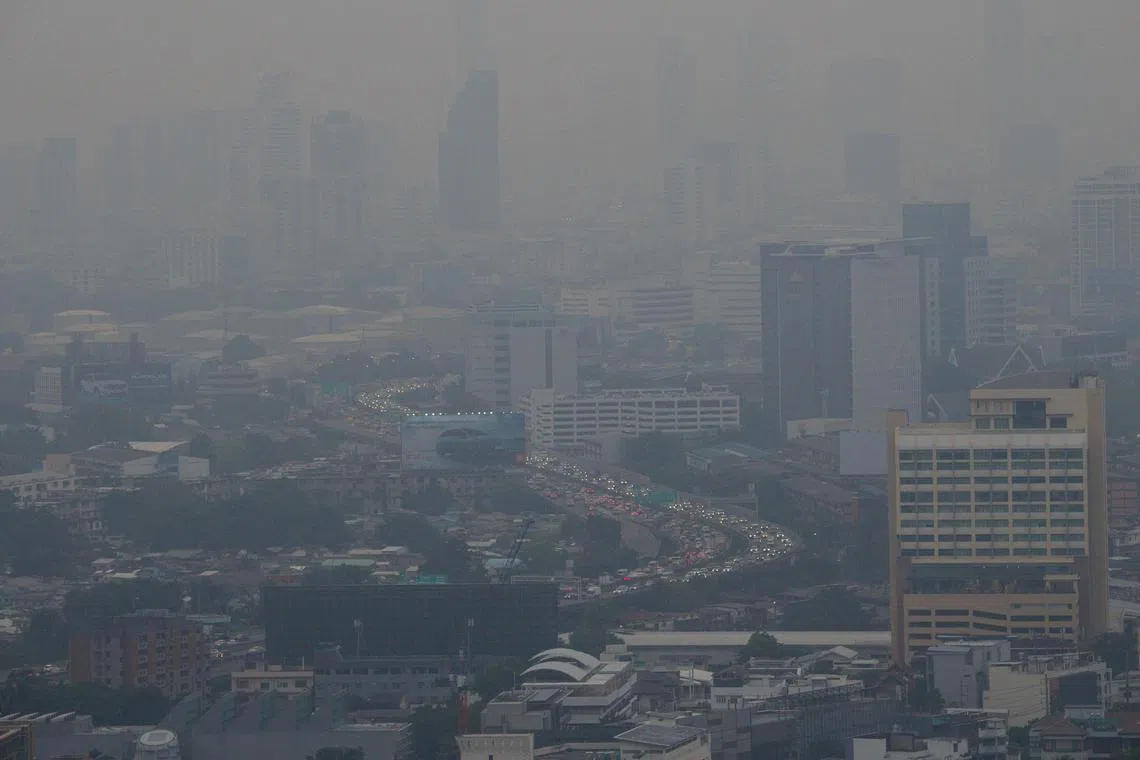 Vehicles sit in traffic on a busy road amid high levels of air pollution in Bangkok on Oct 18, 2023.