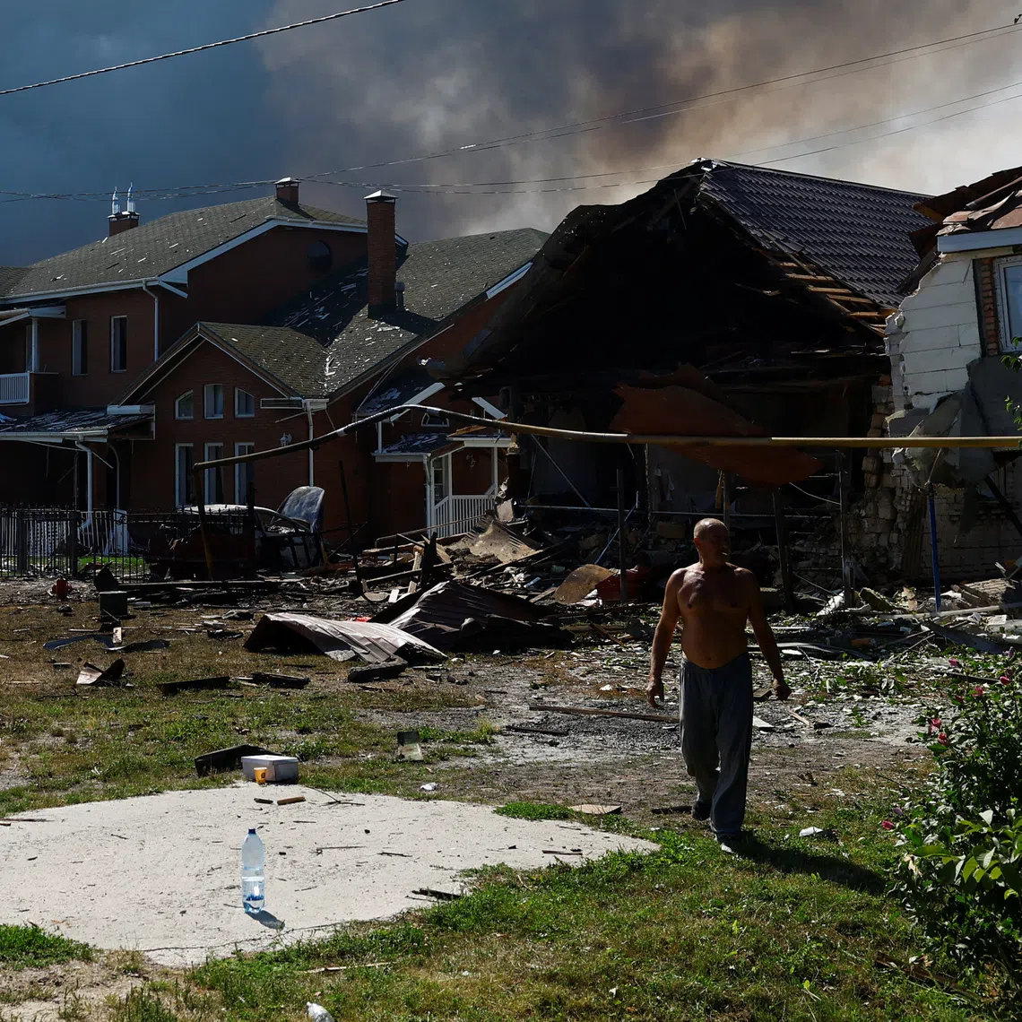 A resident walks next to houses damaged during a Russian drone strike, amid Russia's attack on Ukraine, in Kyiv region, Ukraine, August 27, 2026. REUTERS/Valentyn Ogirenko