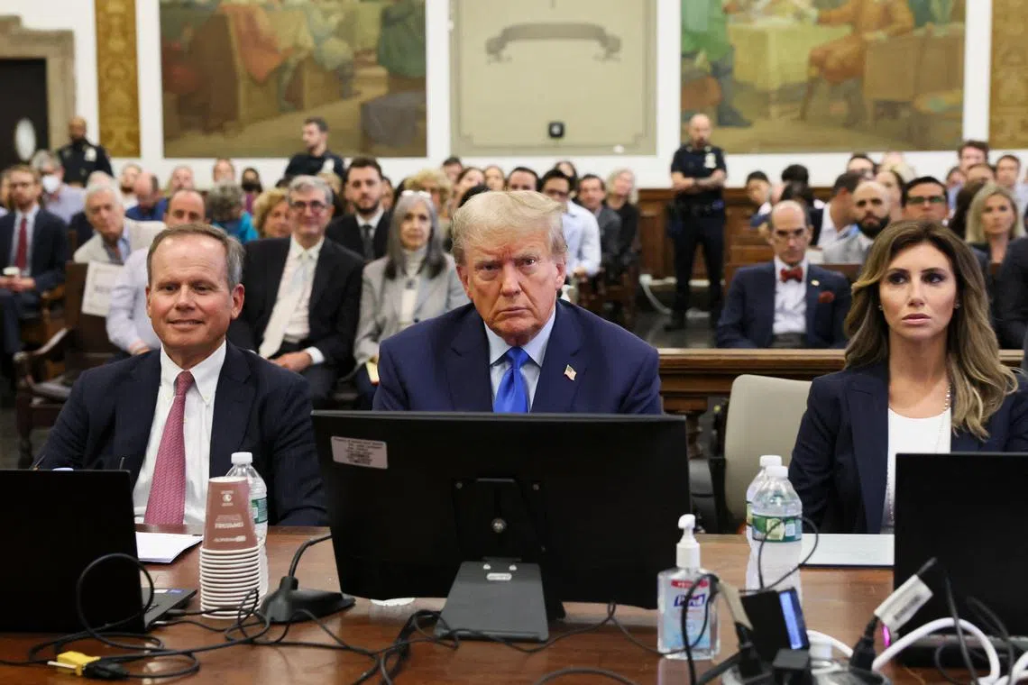 Former US president Donald Trump sits with his attorneys inside a courtroom during a civil fraud case in New York.