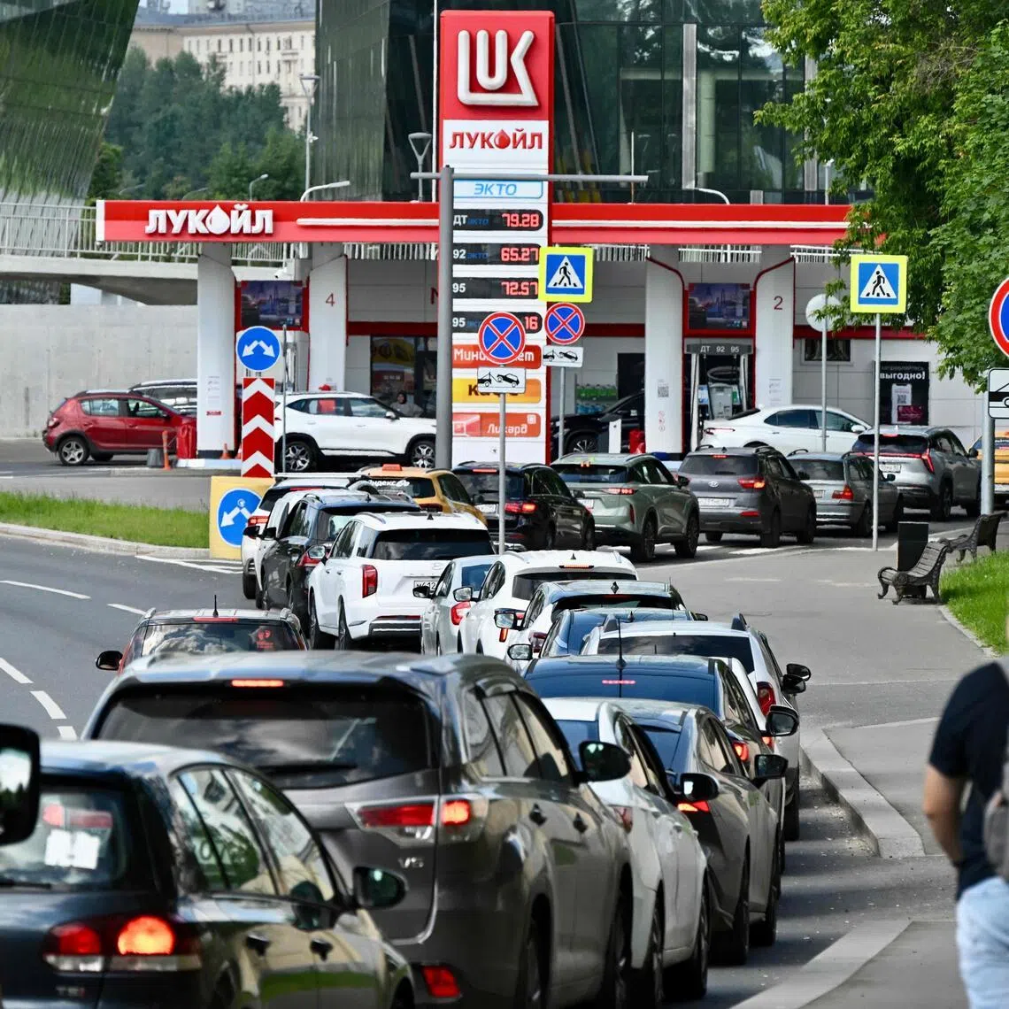 People queue to refuel their cars at a Lukoil petrol station in Moscow, on June 30.