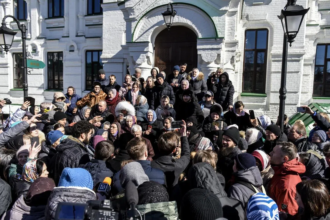 Believers block the entrance to the church, as representatives of a government commission arrive to inspect buildings.
