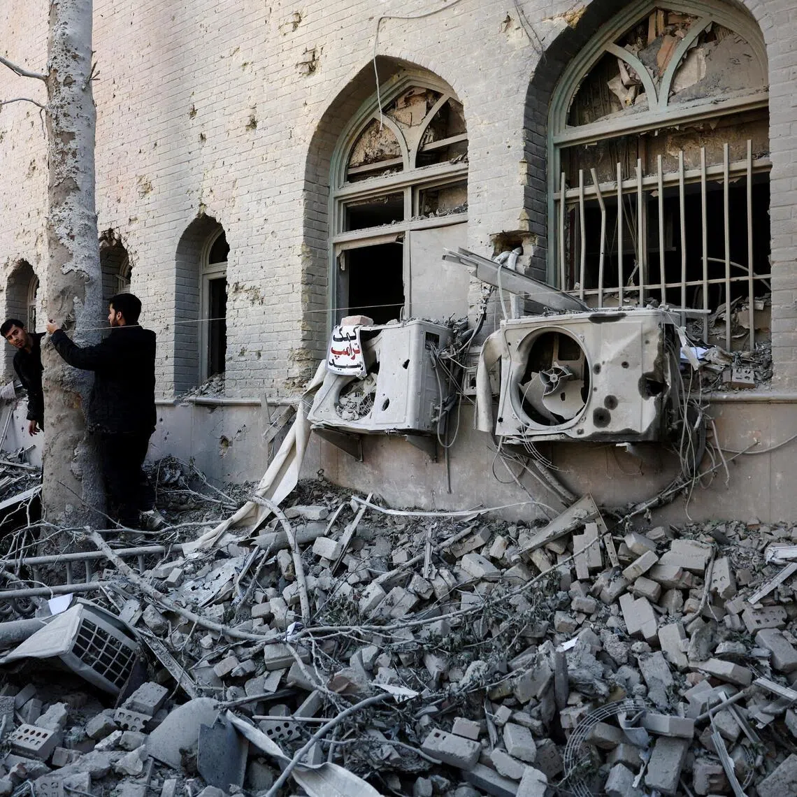 People stand amidst the rubble of a building of the Sharif University of Technology, which was damaged in a strike, amid the US-Israeli conflict with Iran, in Tehran. US-Israeli strikes hit the university in Isfahan, which is among the largest universities in Iran, in March.