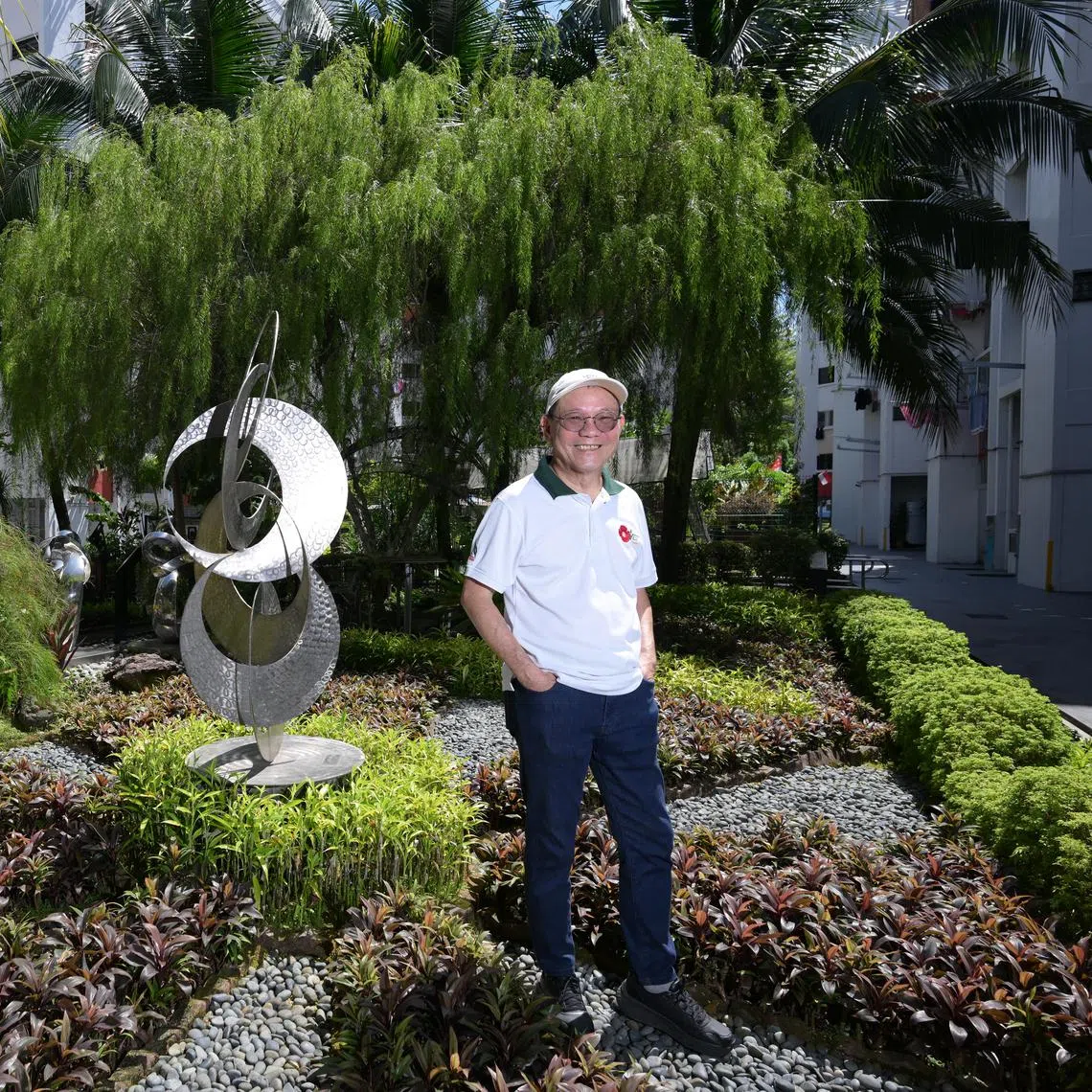 vlbloom/ST20250825_202501600222/Ng Sor Luan/Community garden spaces at the Bukit Batok Residents' Network, including its sculptures and sustainable features like aquaponics. Artist Richard Ashworth with his sculpture Unity.