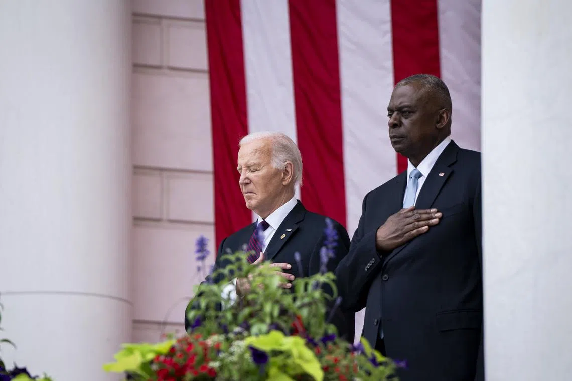 President Joe Biden and Secretary of Defense Lloyd Austin stand for the national anthem during a Memorial Day ceremony at the Memorial Amphitheater at Arlington National Cemetery in Arlington, Va., Monday, May 27, 2024. (Haiyun Jiang/The New York Times)