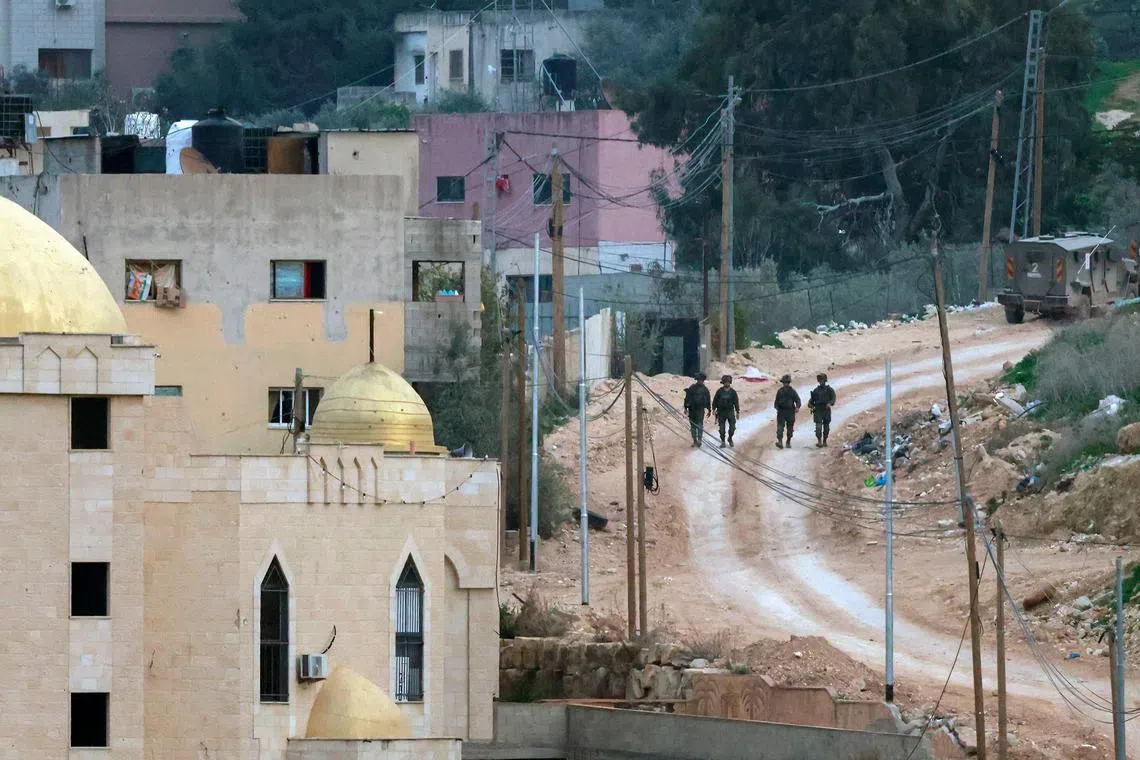 Israeli soldiers walk along a road during a military operation in the Jenin camp for Palestinian refugees in the north of the occupied West Bank on Feb 3, 2025.