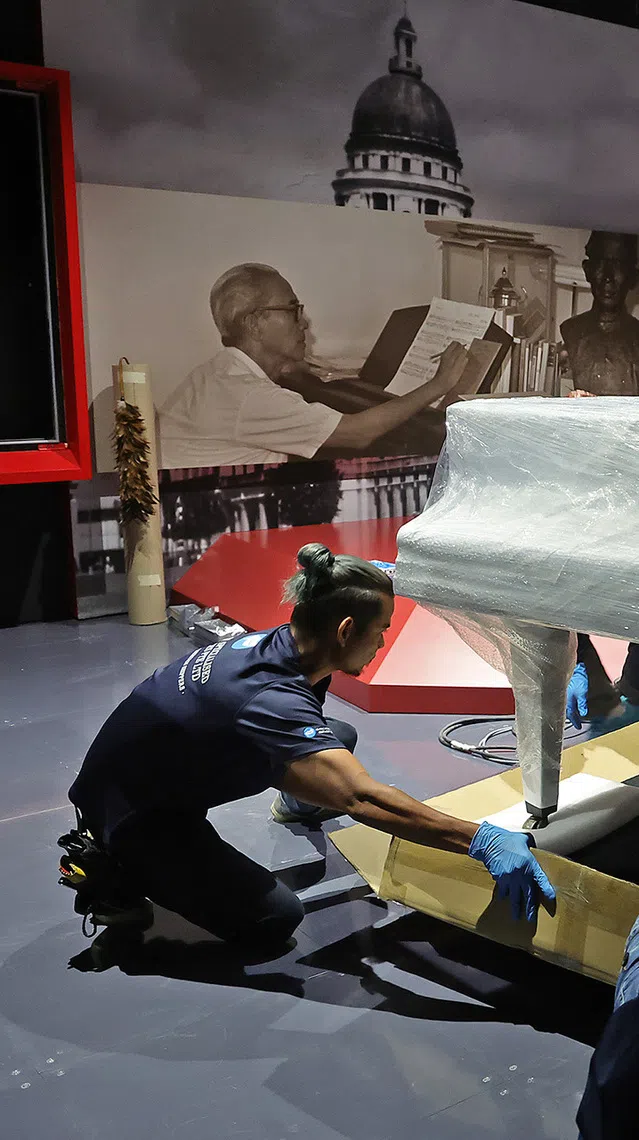 Behind the scenes for the revamp of Singapore History Gallery at National Museum. Software testing for the phygital rickshaw installation on Sept 8, 2026. Installation of the late Lee Kuan Yew's artefacts for the section on LKY’s legal career and start in politics on Aug 28, 2026. Inspection and installation of the Singapore Stone into the showcase on Aug 20, 2026. Installation of the Zouk signboard, Phuture signboard and septagon chair on Aug 14, 2026. Art handlers moving the late composer Zubir Said's piano, guided by its curator and conservator, into position on July 21, 2026.