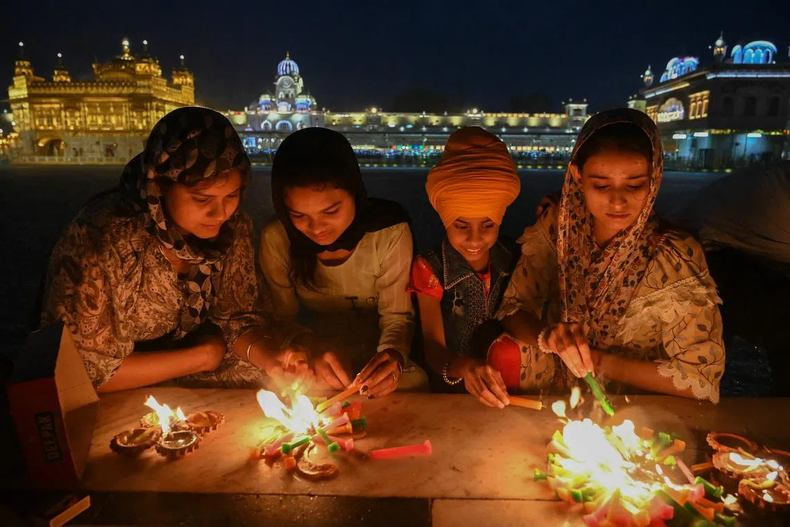 Sikh devotees light candles at the illuminated Golden Temple on the occasion of birth anniversary of Guru Tegh Bahadur, in Amritsar, India,  on April 29, 2024. 