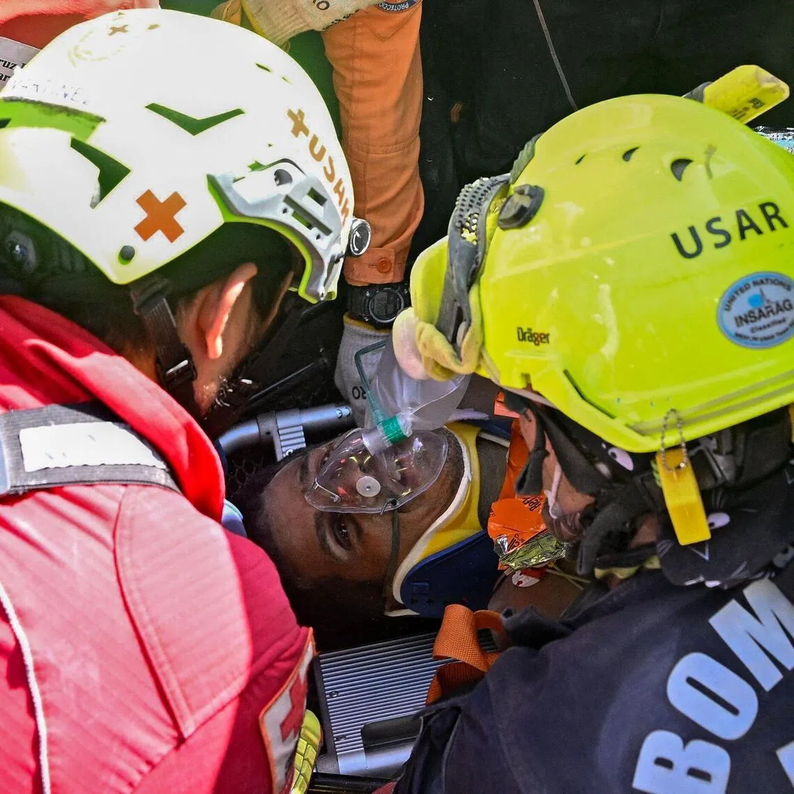 An international rescue team assists a survivor of Venezuela’s twin earthquakes in Catia La Mar, La Guaira State, Venezuela on July 2, eight days after the quake.