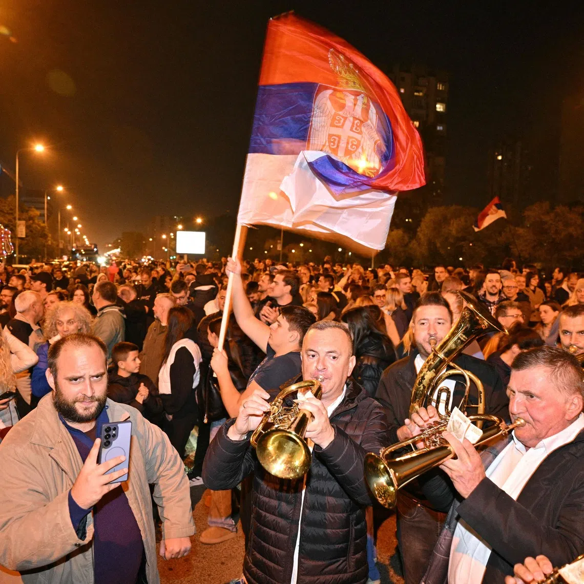 Supporters of the Students’ List wave a giant Serbian flag as they celebrate their victory in the Serbian parliamentary elections on Oct 25.