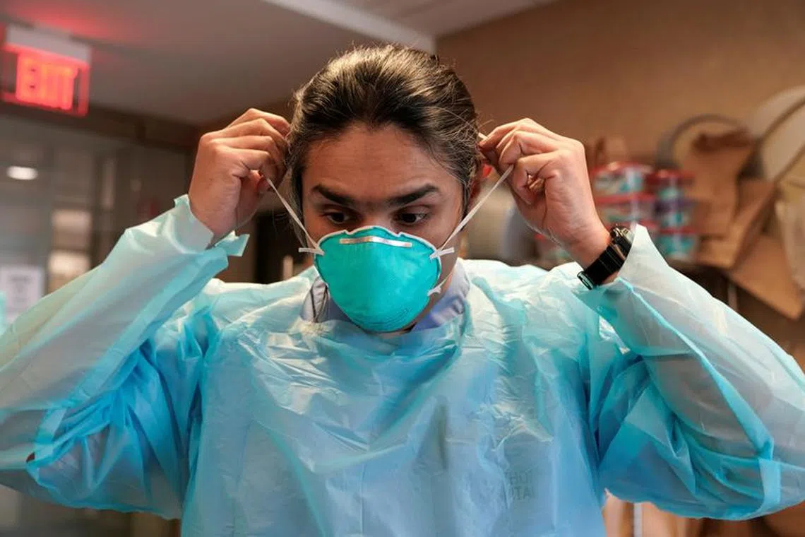 FILE PHOTO: Dr. Syed Naqvi, a pulmonologist, dons an N95 mask before entering the ICU at SSM Health St. Anthony Hospital amid the outbreak of the coronavirus disease (COVID-19) in Oklahoma City, Oklahoma, U.S., January 28, 2021.  REUTERS/Nick Oxford/File Photo