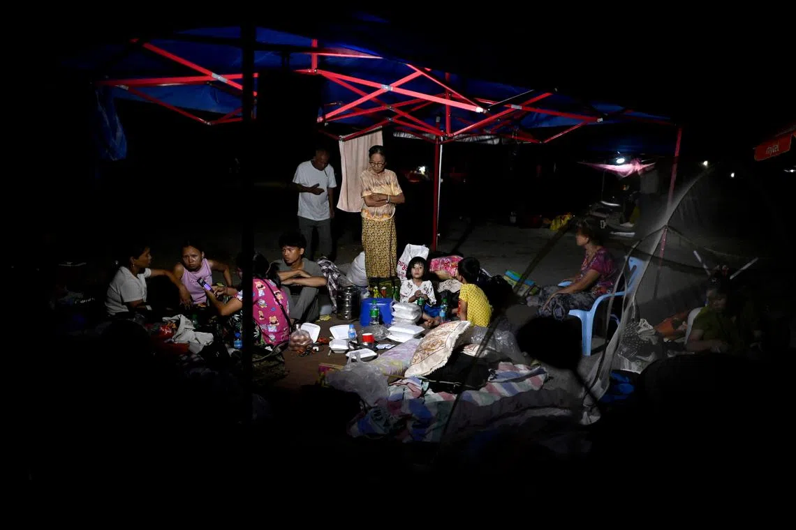 People take shelter in temporary tents set up outdoors in Mandalay on March 31, 2025, three days after the deadly Myanmar earthquake. Myanmar declared a week of national mourning on March 31 for the country's devastating earthquake, as the death toll passed 2,000 and hopes faded of finding more survivors in the rubble of ruined buildings. (Photo by Sai Aung MAIN / AFP)
