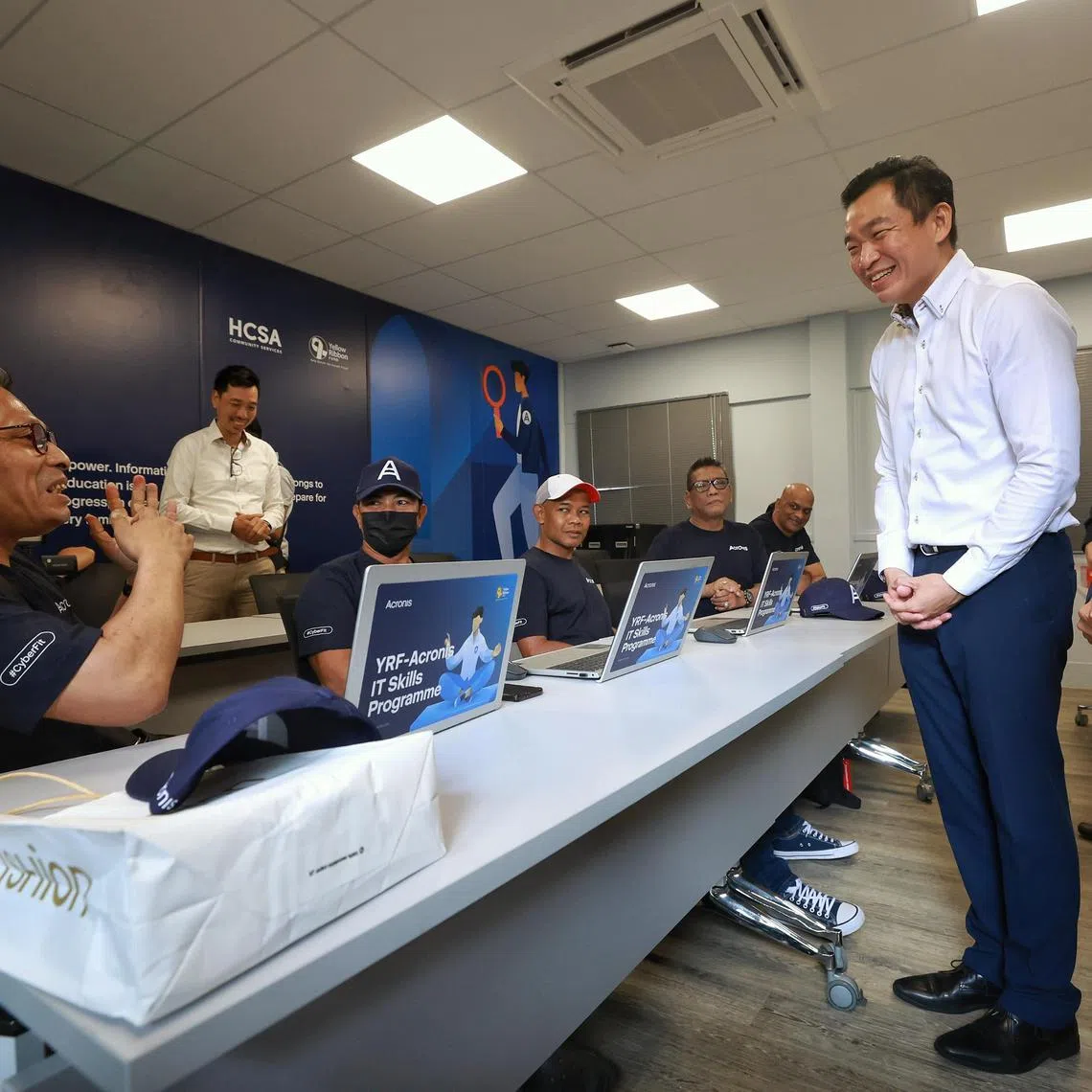 Ex-offender Hameed Maricar Bin Ahamed Maricar (left), 53-year-old self-employed batik artist, sharing with Senior Parliamentary Secretary for Culture, Community and Youth, and Social and Family Development Eric Chua how learning to create presentation slides has helped him in his work during the launch the Acronis-HCSA computer classroom at HCSA Community Services on April 17, 2023. With SPS Chua are (from right) HCSA Board of Directors vice-president Yeo Jih-Shian and Acronis Senior Vice-President Pasha Ershow. ST PHOTO: KEVIN LIM hnhcsa17