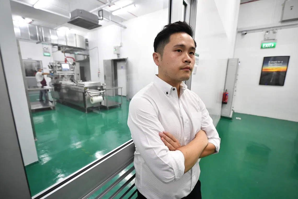 ST20200820-202061827249-Lim Yaohui-Choo Yun Ting-ytdist/
Mr Jeffery Loh, 32, Director of Chee Song Foods, standing outside the packing room with the thermoforming packing machine inside at CS Foods' kitchen facility on Aug 20, 2020.
Profile of food distributor Chee Song Foods, which has added new services such as cook-chill solutions for its F&B customers. Cook-chill system is an advanced food preparation designed to provide more flexibility and ensure food safety in food service. It expanded its facility in March, which has enabled it to cater to the increasing needs of F&B establishments which are dealing with manpower shortages during this Covid-19 pandemic.
(ST PHOTO: LIM YAOHUI)