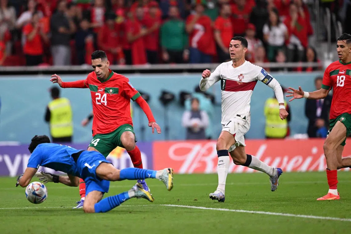 Morocco's goalkeeper #01 Yassine Bounou saves a shot by Portugal's forward #07 Cristiano Ronaldo during the Qatar 2022 World Cup quarter-final football match between Morocco and Portugal at the Al-Thumama Stadium in Doha on December 10, 2022. (Photo by Kirill KUDRYAVTSEV / AFP)
