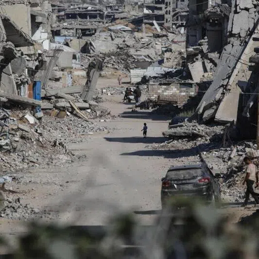 Palestinians making their way through destroyed buildings in Khan Younis in the southern Gaza Strip.