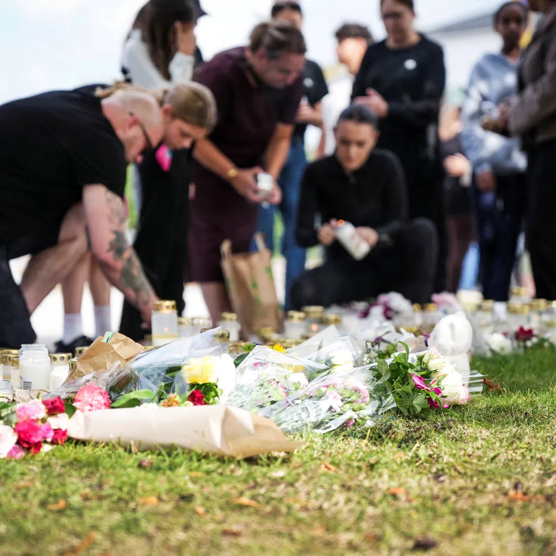 A makeshift memorial outside a school in Sweden where a man with a sword killed a 17-year-old girl.
