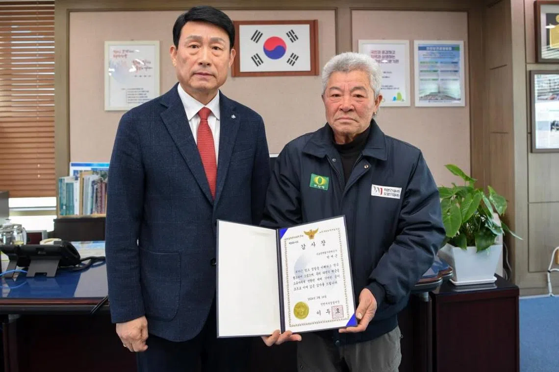 Park Jae-geun (right) was awarded a prize from Incheon Seobu Police Station at the office of Sudokwon Landfill Site Management Corp. in Incheon.