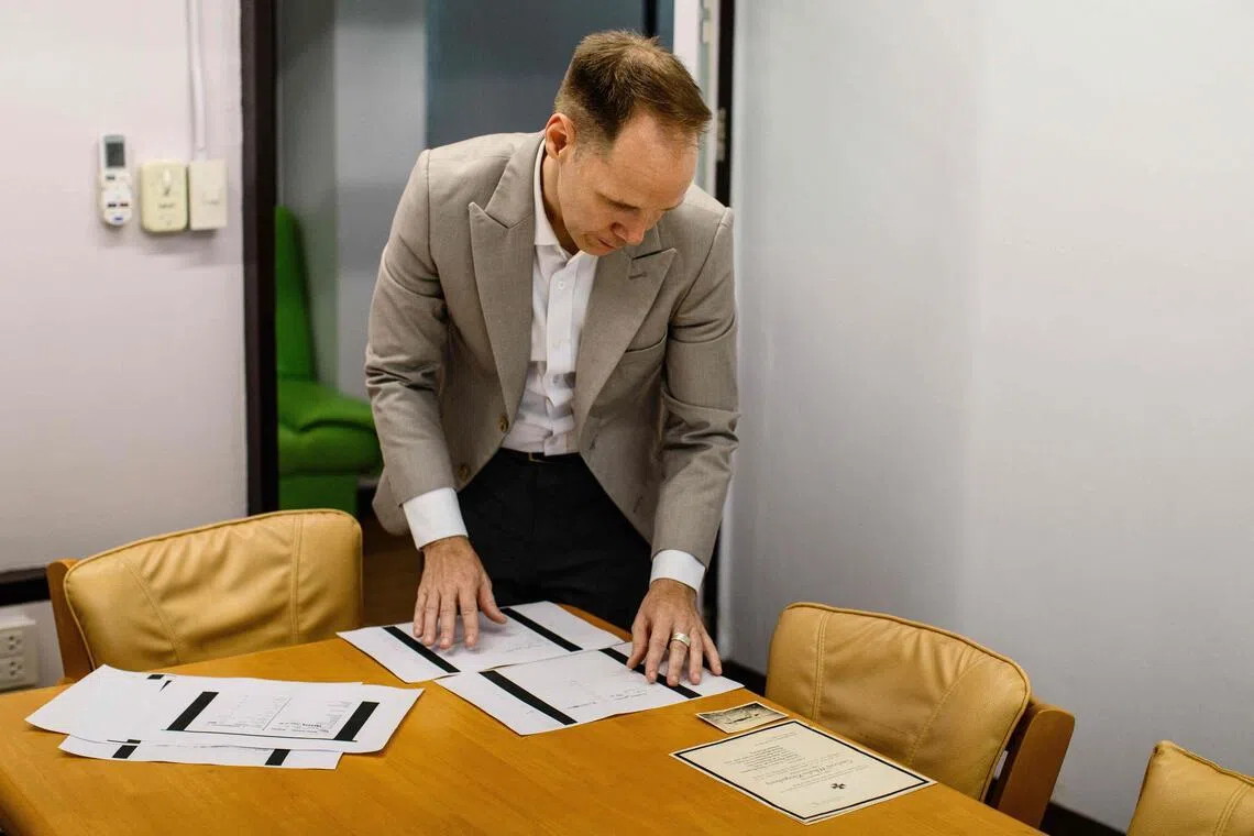 German lecturer Felix Puelm looks at copies of National Socialist German Workers’ party membership cards of several members of his family, at Silpakorn University in Nakhon Pathom province, west of Bangkok, on June 2. 