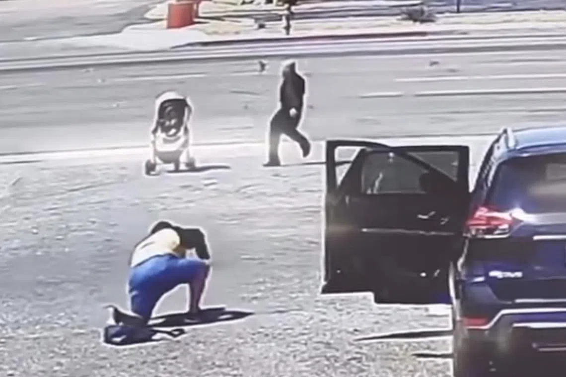 In surveillance video, a person is seen loading up a parked car when a stroller with a baby starts rolling towards a busy road. 