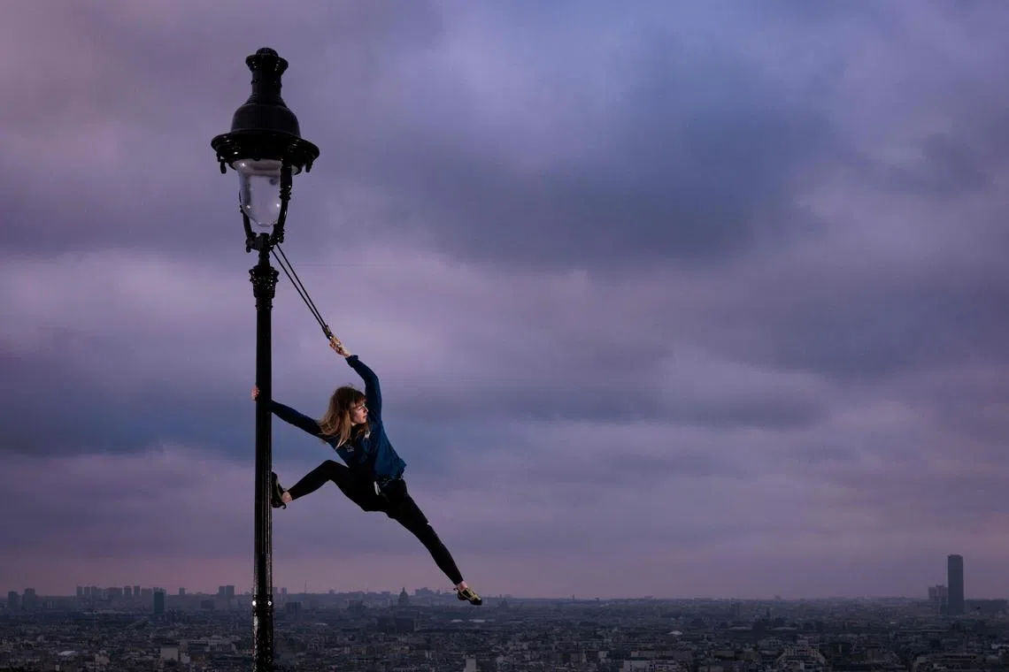 France climber Capucine Viglione posing on a street lamp in Paris on May 22, ahead of the Paris 2024 Olympic and Paralympic Games.