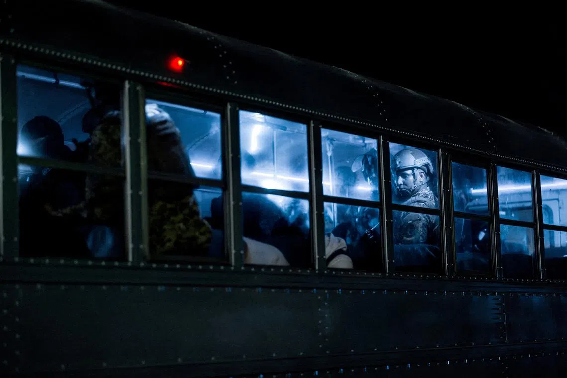 Salvadoran police officers escort alleged members of the Venezuelan gang Tren de Aragua recently deported by the U.S. government to be imprisoned in the Terrorism Confinement Center (CECOT) prison, as part of an agreement with the Salvadoran government, in Tecoluca, El Salvador, in this handout image obtained March 16, 2025. Secretaria de Prensa de la Presidencia/Handout via REUTERS/File Photo