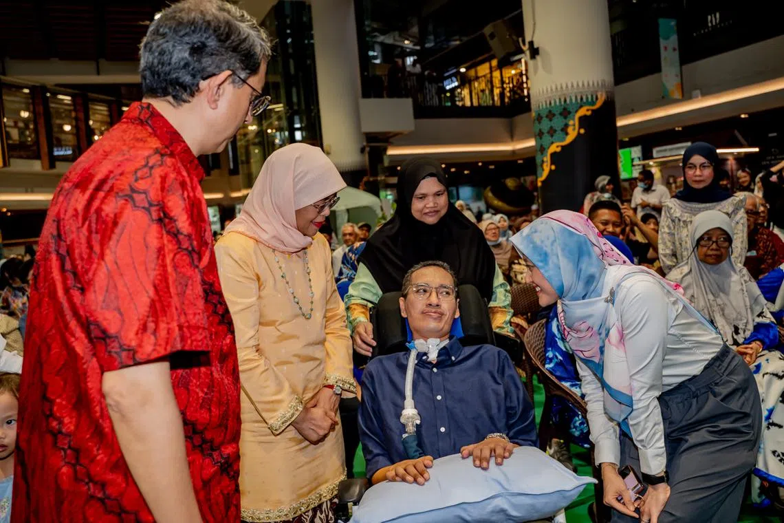 President Halimah Yacob (second from left), Minister Muhammad Faishal Ibrahim (left) and Senior Parliamentary Secretary Rahayu Mahzam (right) speaking to ex-journalist Asri Sunawan.