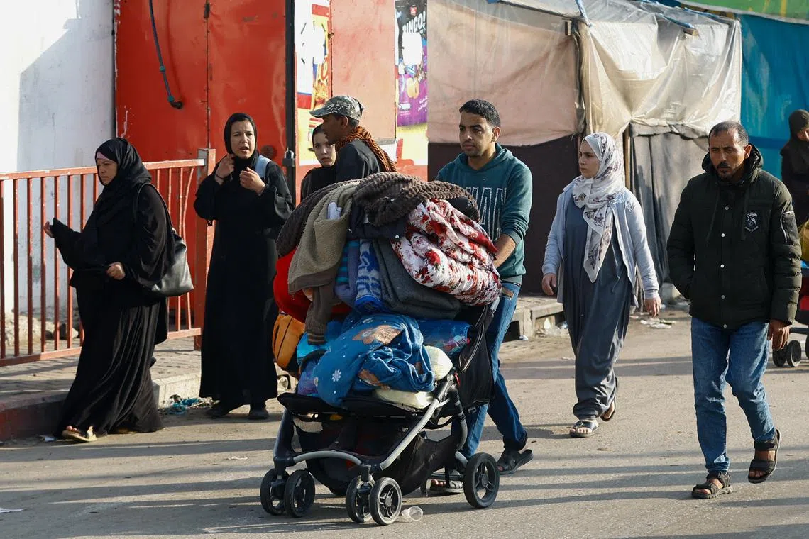 Palestinians fleeing their houses due to Israeli strikes in the eastern part of Khan Younis on Dec 1.